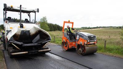 Road workers resurfacing road Road workers resurfacing road