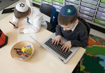 Pupils writing and using laptop Pupils writing and using laptop